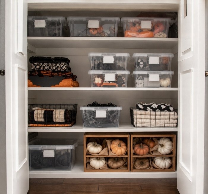 Organized storage of Halloween decorations in labeled containers.